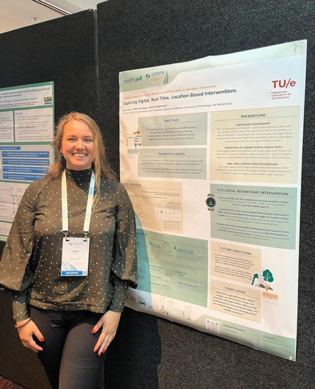 Female researcher standing next to her scientific poster on digital, real-time, location-based interventions at ISBNPA 2025